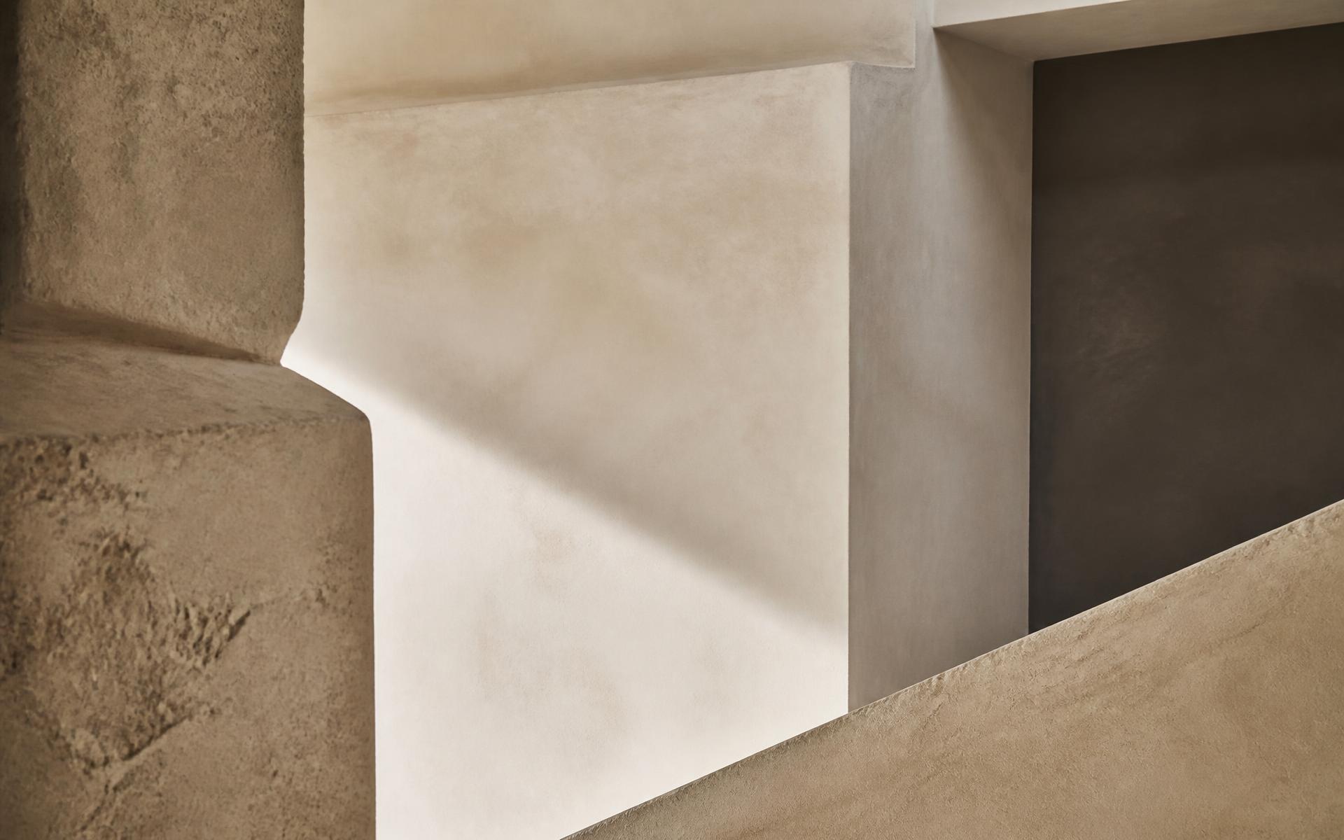 Warm limestone and plaster architectural forms in raking daylight